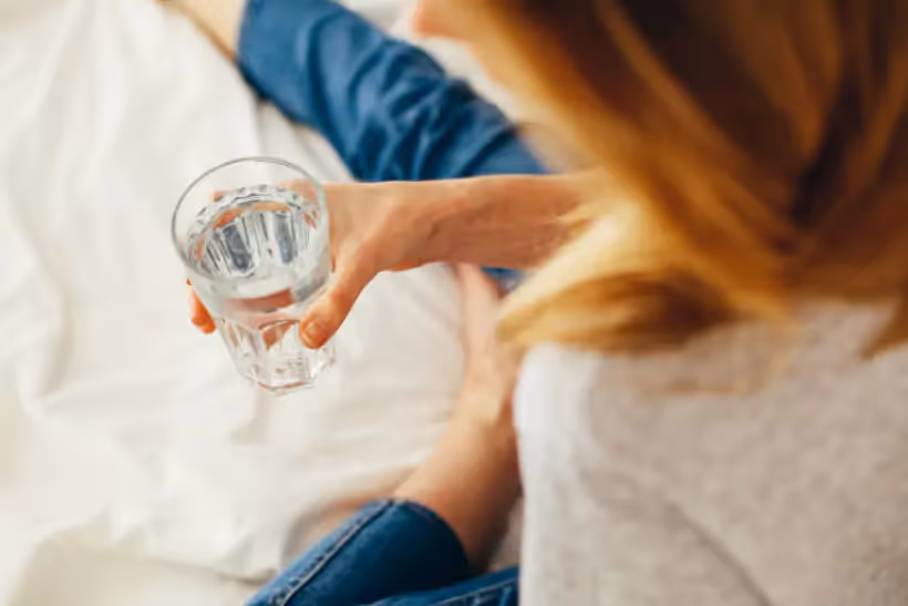 a person holding a glass of water