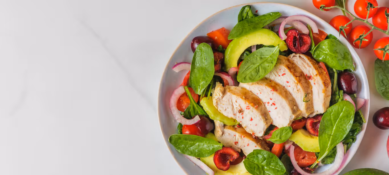 A white bowl filled with whole foods like avocado and chicken to represent the Whole30 diet
