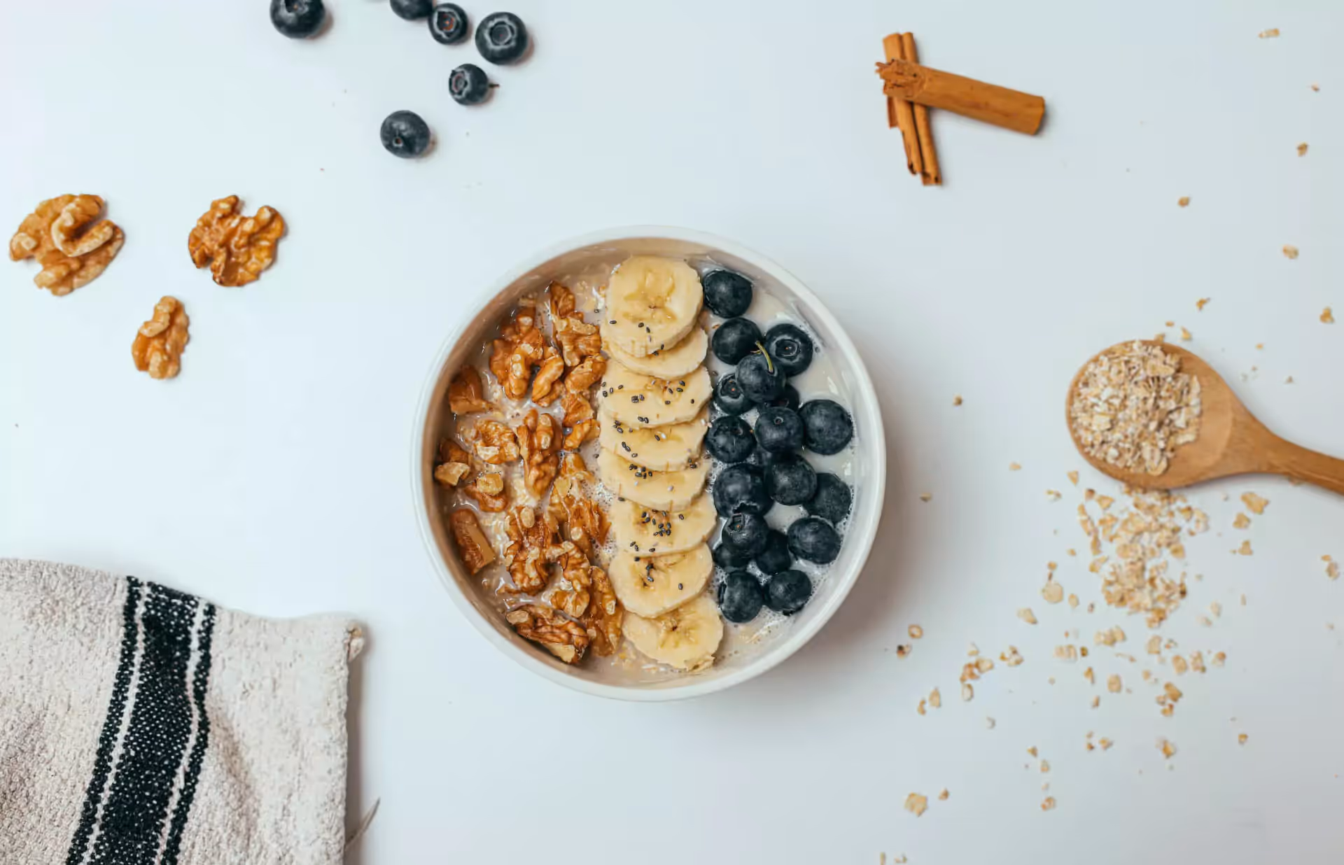 a bowl of wheat bran, blueberries, bananas and walnuts