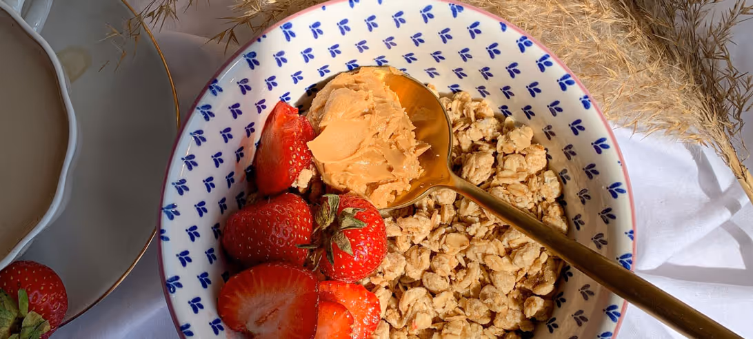 A bowl of cereal, milk and fruits