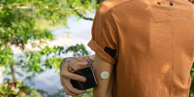 A person scanning a CGM sensor with a smartphone