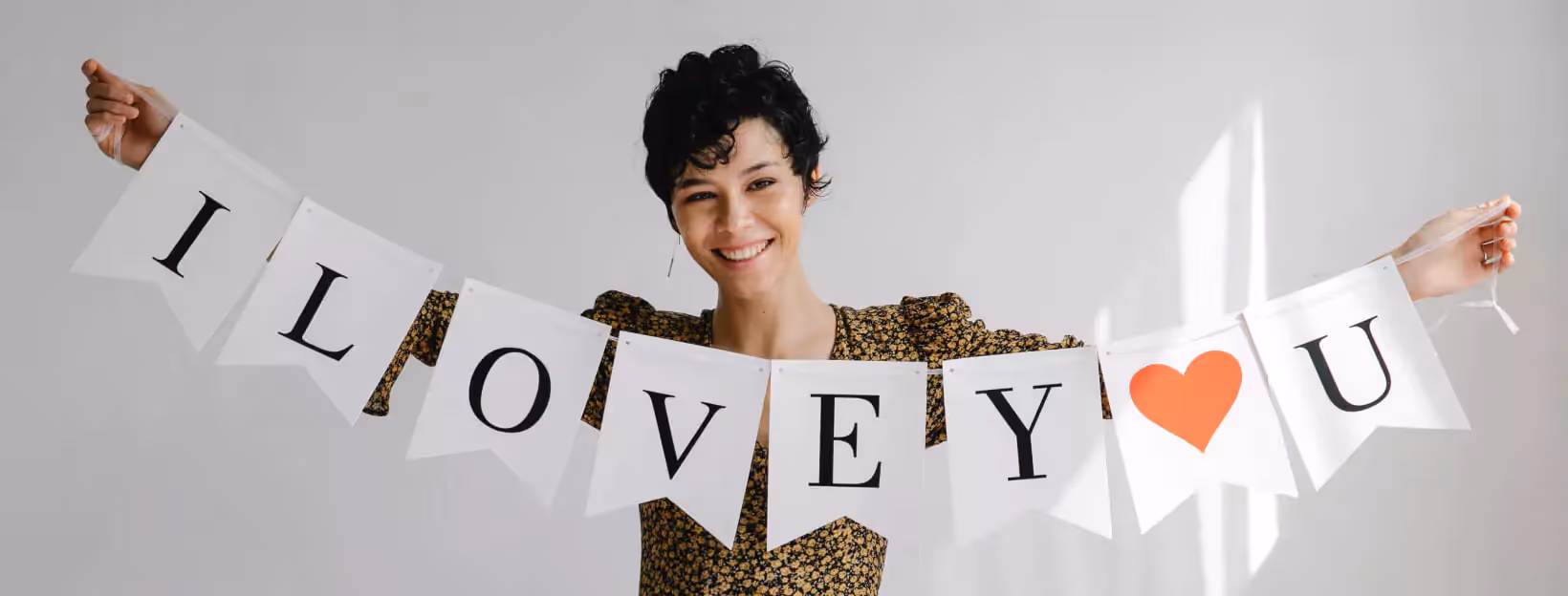 a person holding a sign that showing "I love you"