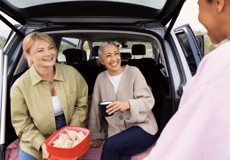 two people in a car with some snacks