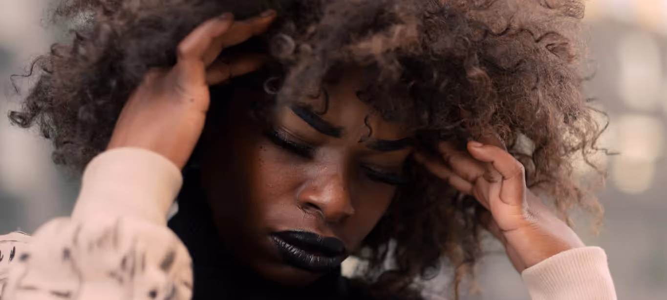 a girl holding her head in pain