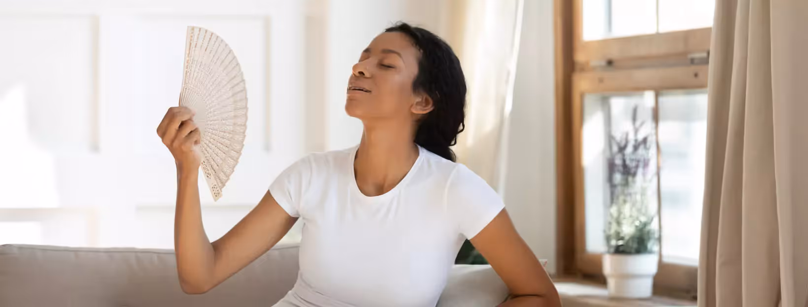 A person fanning themselves with a handfan