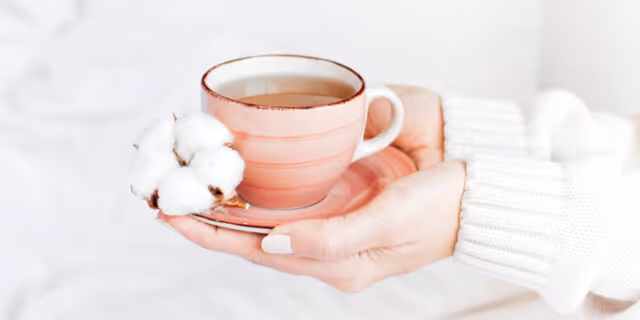 a person holding a cup of tea