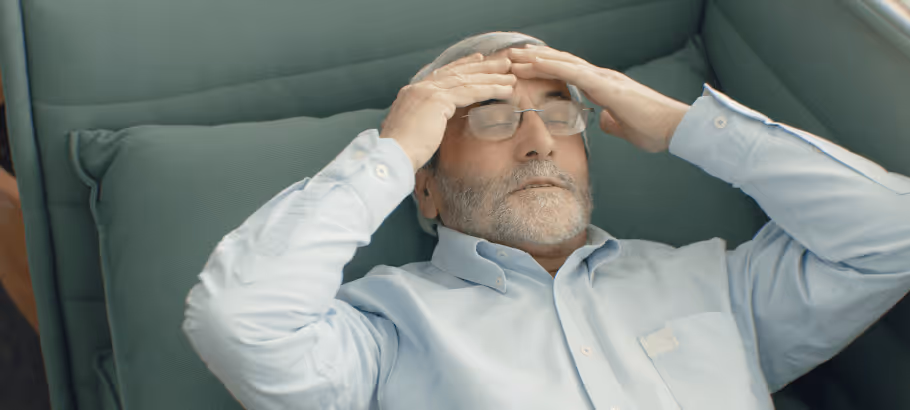 a man holding his head in pain