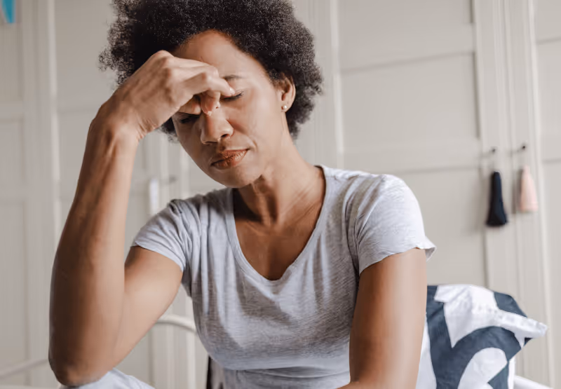 someone feeling tired and experiencing headache