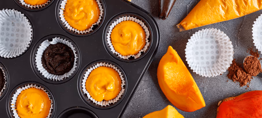 a baking tray with pumpkin muffins