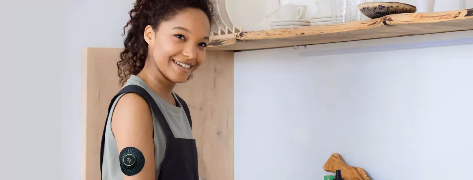 a person wearing Nutrisense CGM and standing in the kitchen