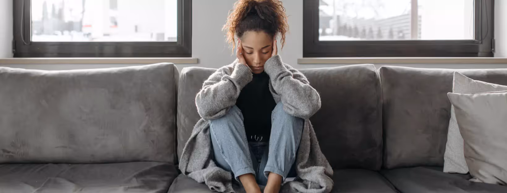 a person sitting on a sofa with their eyes closed