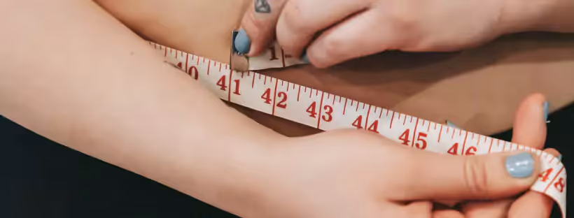 a person measuring their waist