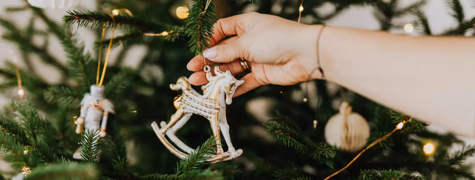 A person decorating a Christmas tree