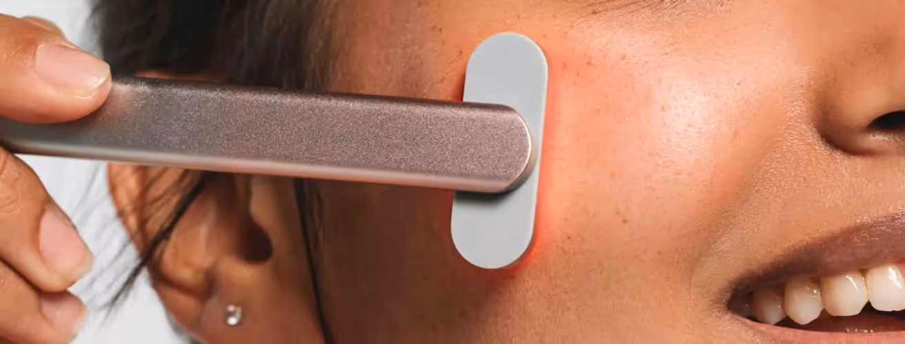 Woman using a red light therapy device