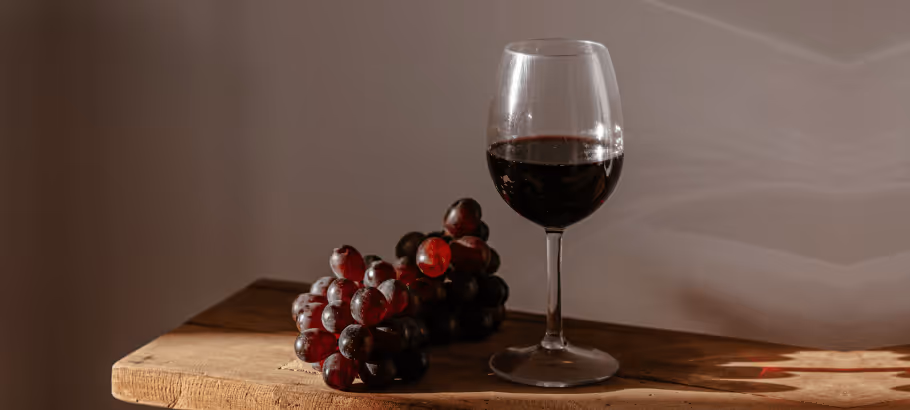 a bunch of grapes and a glass of red wine