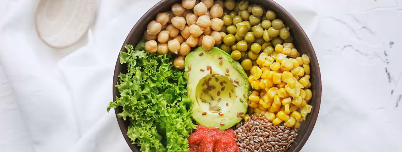 a bowl of salad, chickpeas, avocado, peas and corns