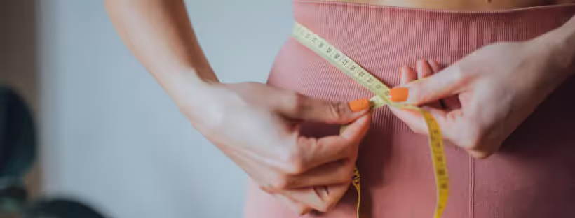 a person measuring their waist