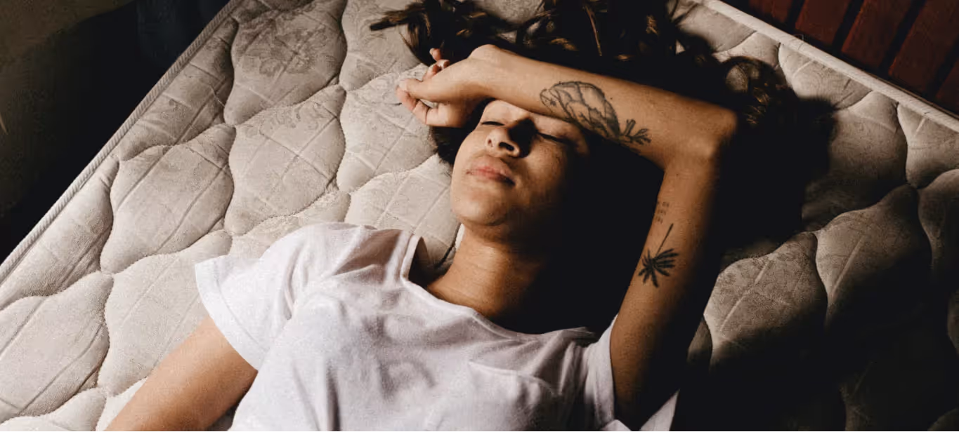 a woman laying down with her hand over her head