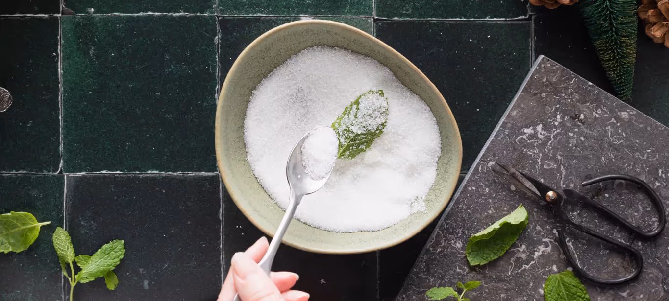 a person holding a spoon full of sugar