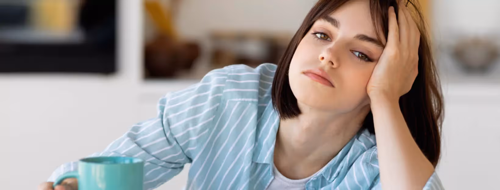 a person drinking coffee and looking tired