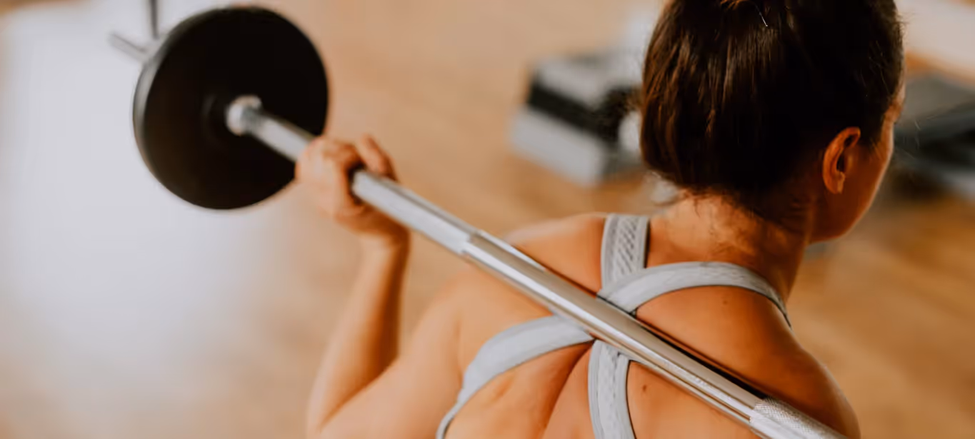 a woman performing a barbell exercise