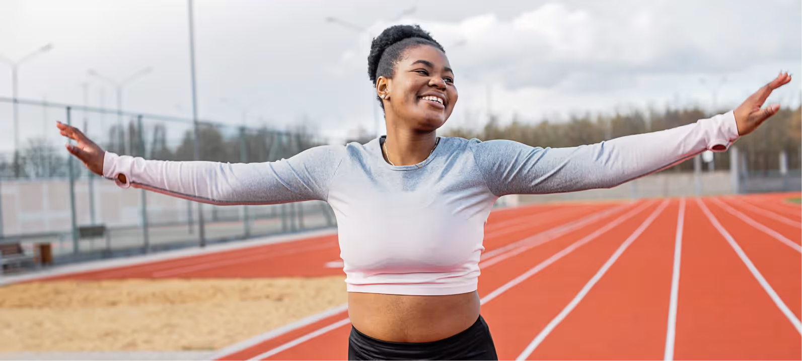 a woman in workout clothes standing on a running track
