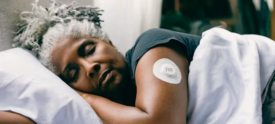 a woman with a nutrisense cgm sleeping