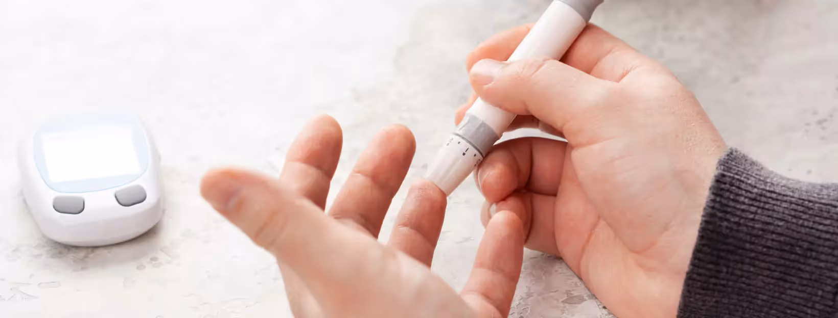Person pricking their finger for blood glucose testing