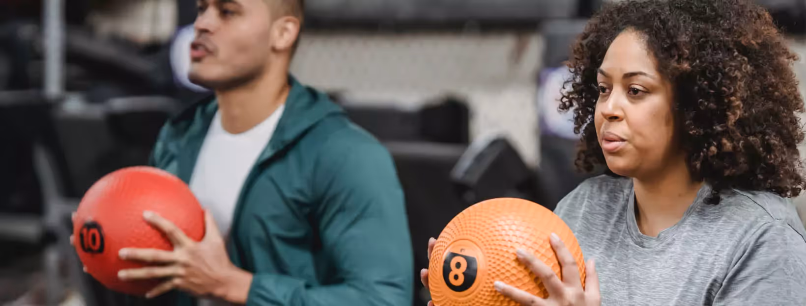 two people doing exercises with weighted ball