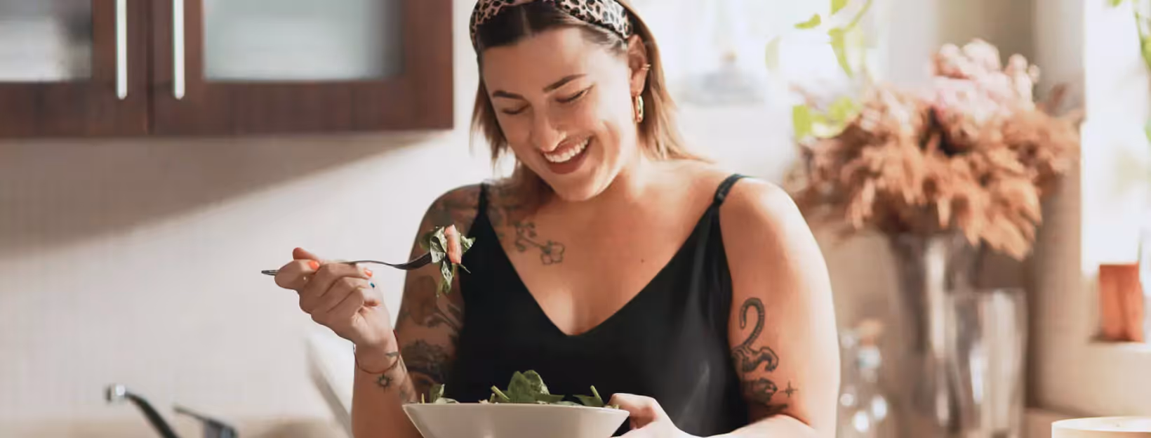 a person eating a salad in the kitchen