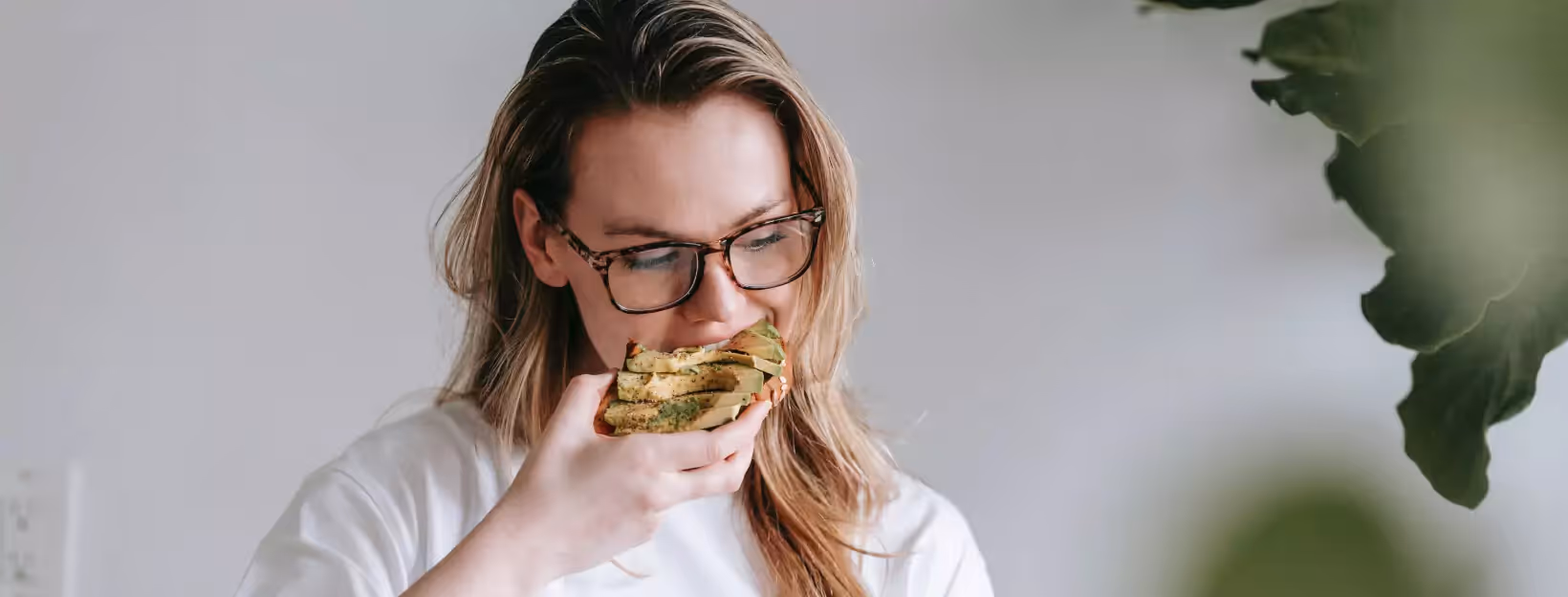 a person eating a toast with avocado