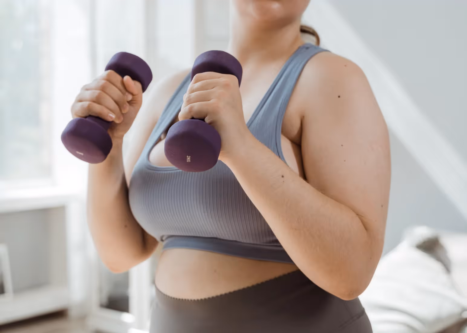 a woman with light dumbbells