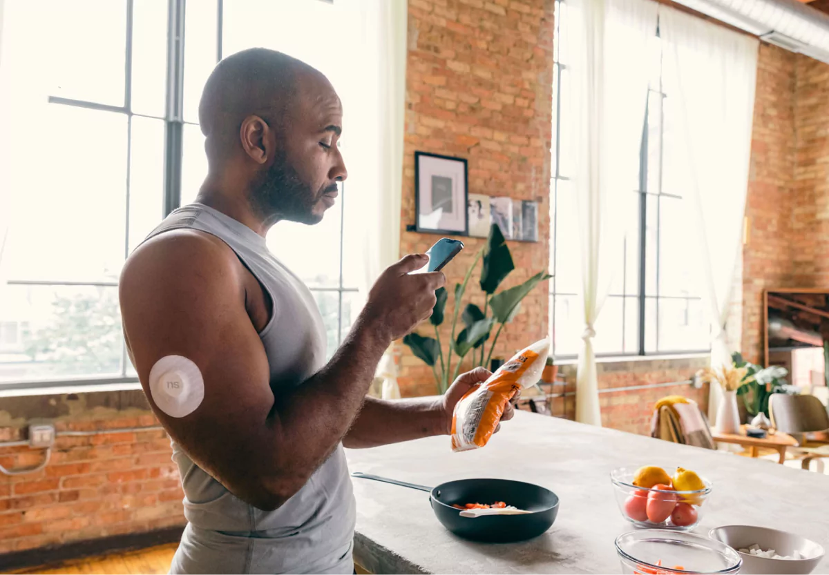 a man wearing a cgm and scanning his meal with the nutrisense app