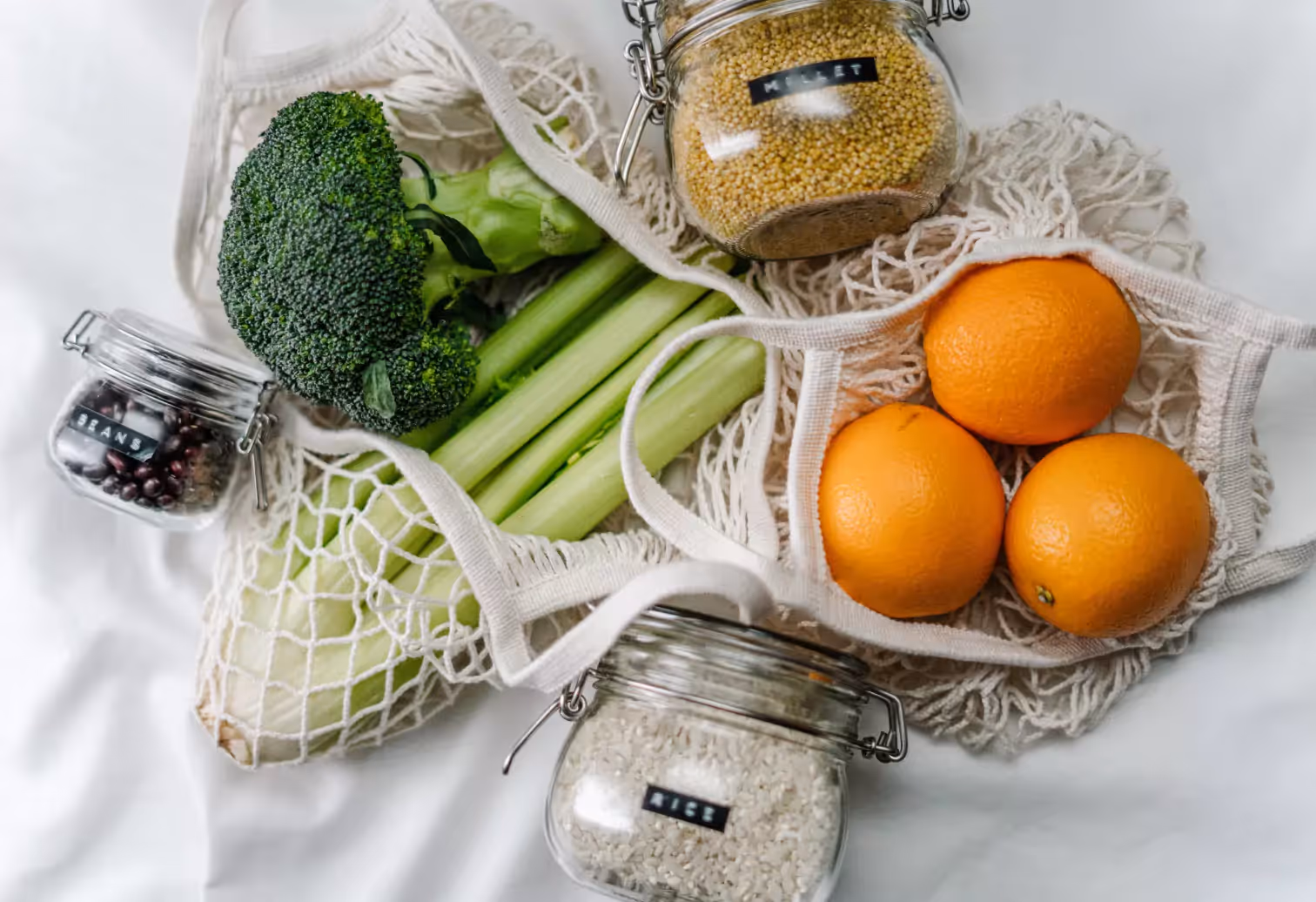 bags of veggies and oranges and jars of different types of groats