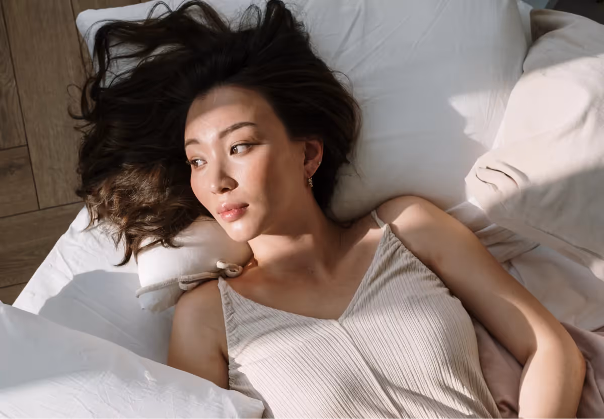 a woman laying in bed in the morning