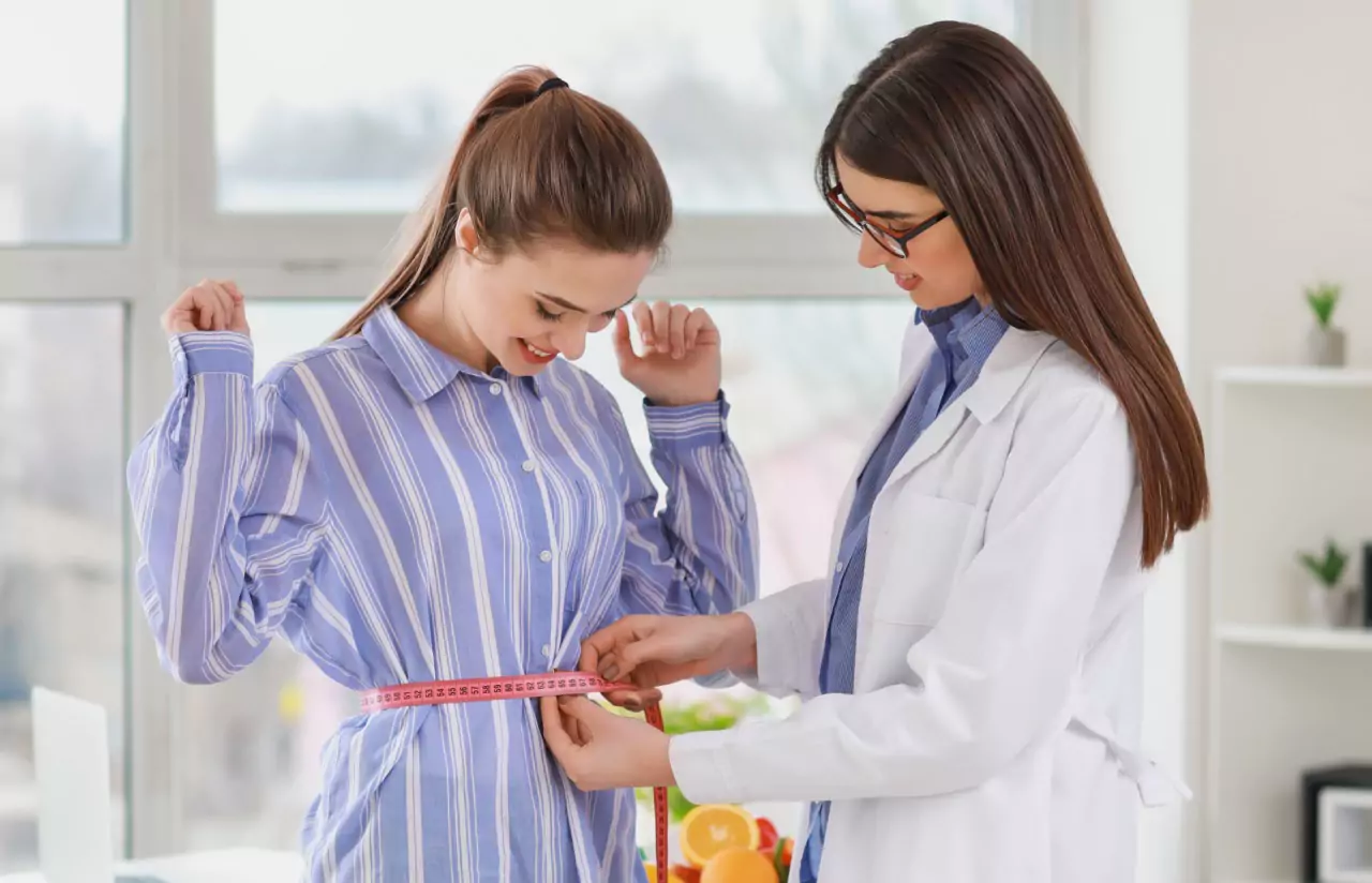 A doctor measuring a persons waist