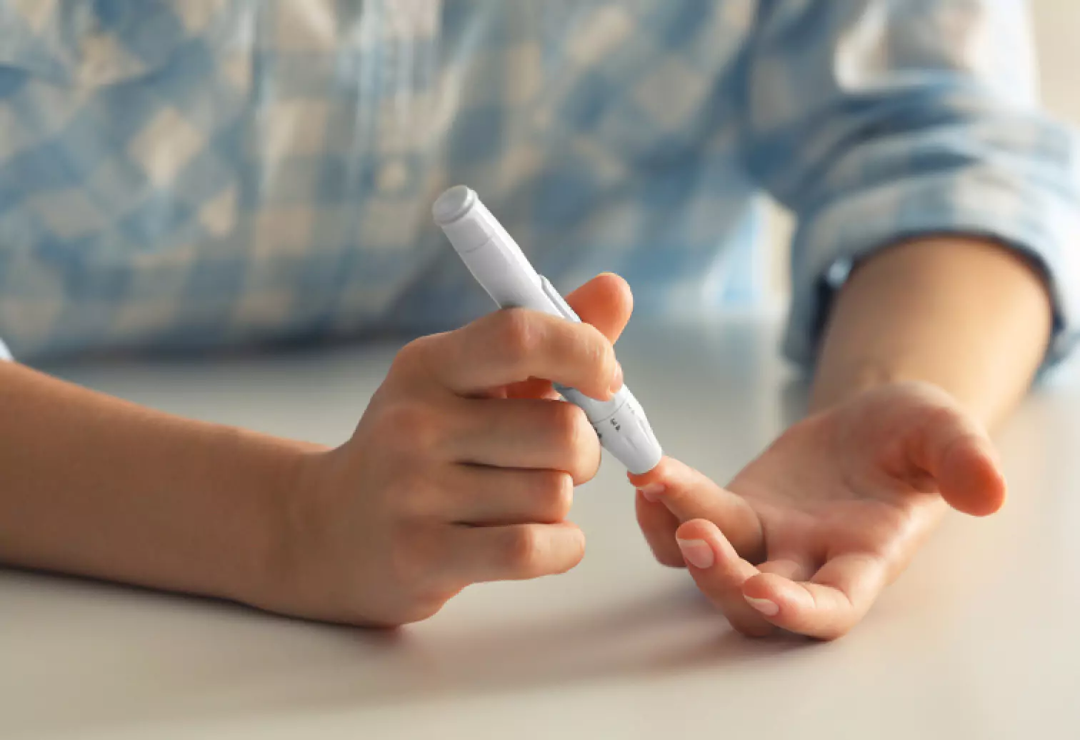 a person using finger prick method to test their glucose level