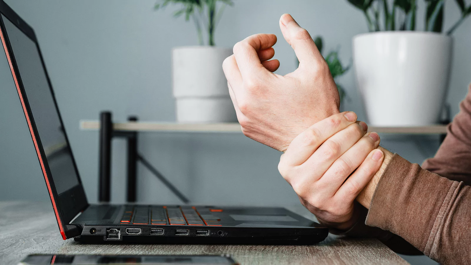 A person holding their wrist after typing