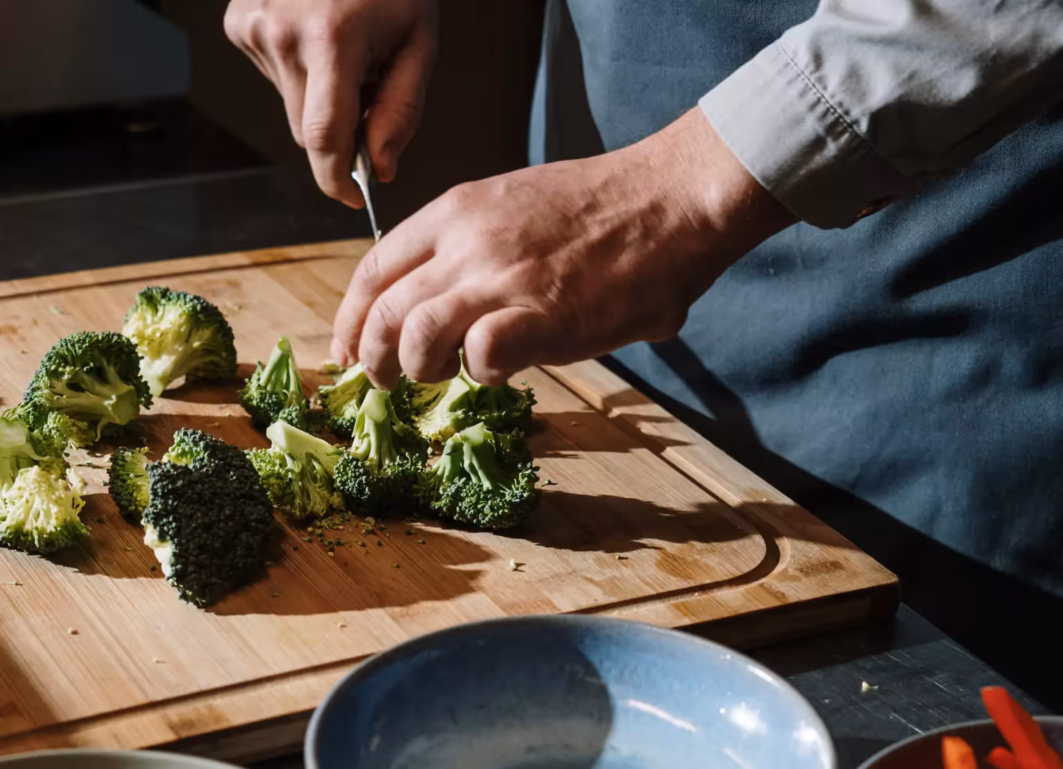 a person cutting broccoli