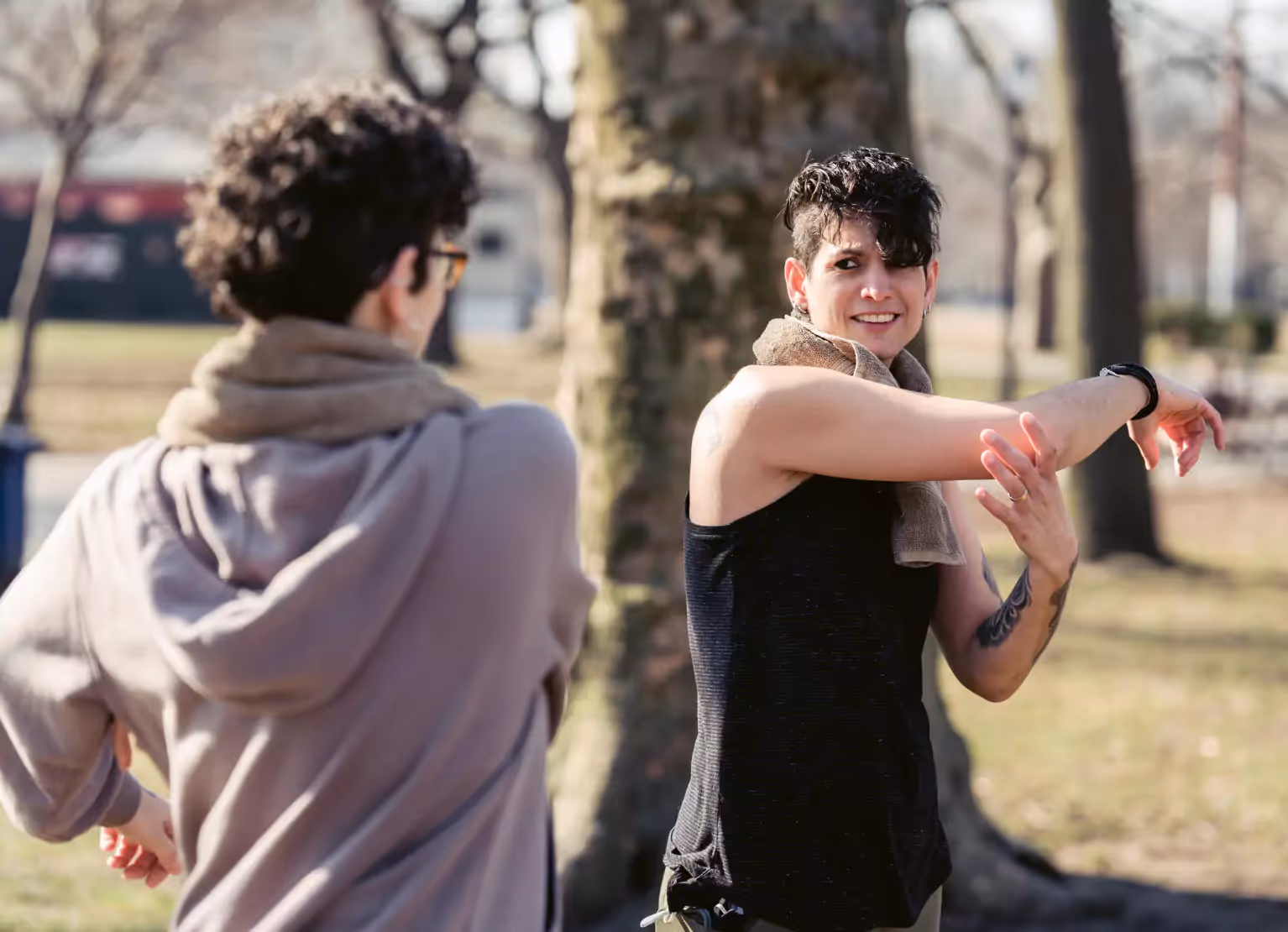 Two people stretching in a park