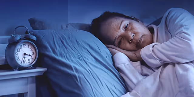 a person laying in bed with their eyes opened 