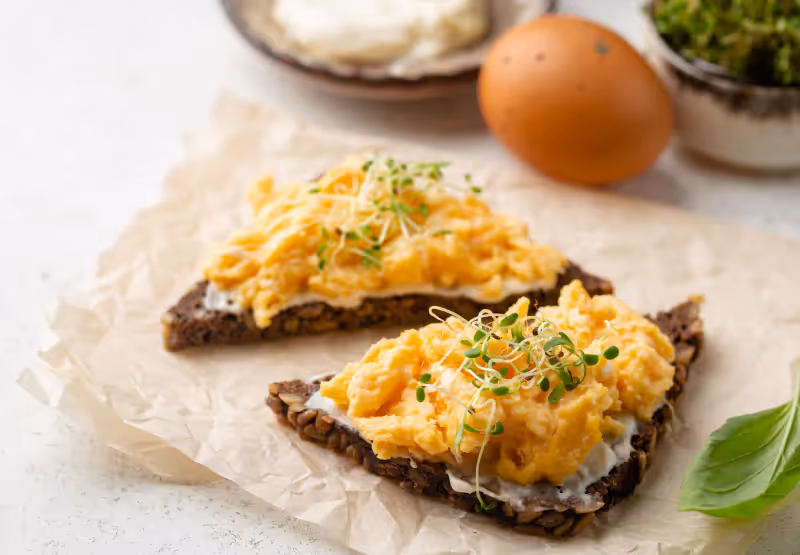 two toasts with scrambled eggs