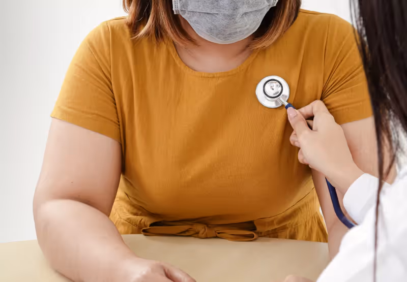 a heavy set person getting their heartbeat checked at the doctor