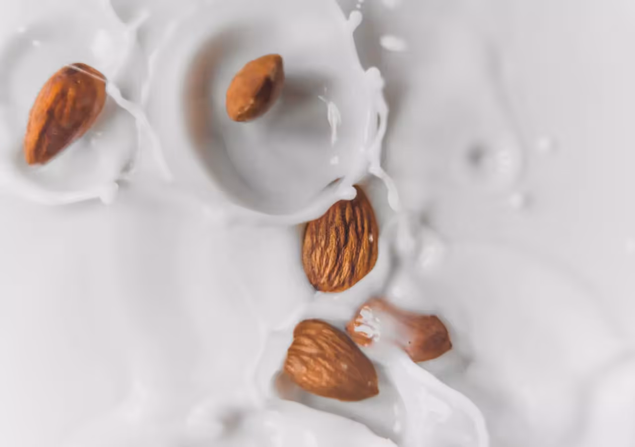 An aerial shot of almonds falling into milk