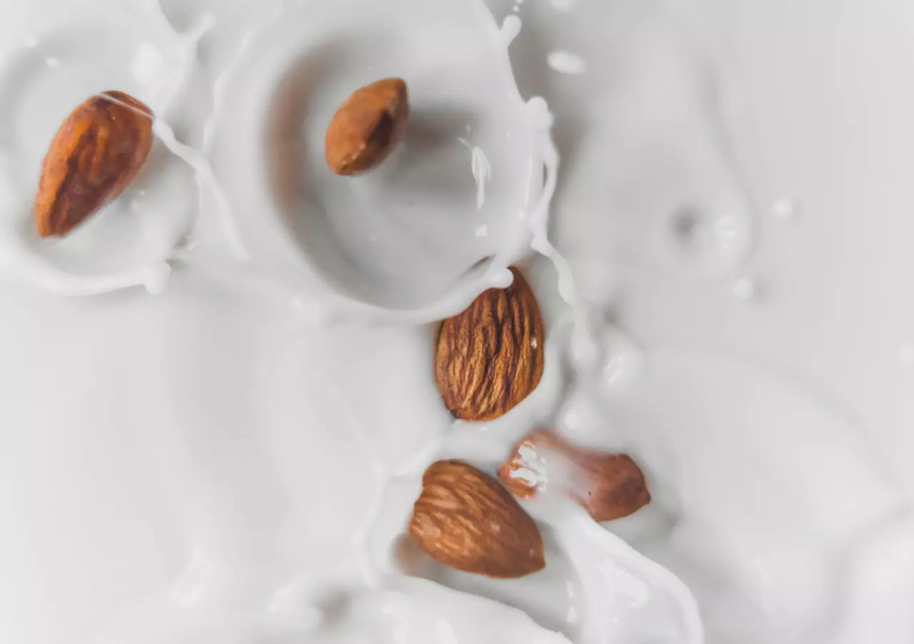 An aerial shot of almonds falling into milk