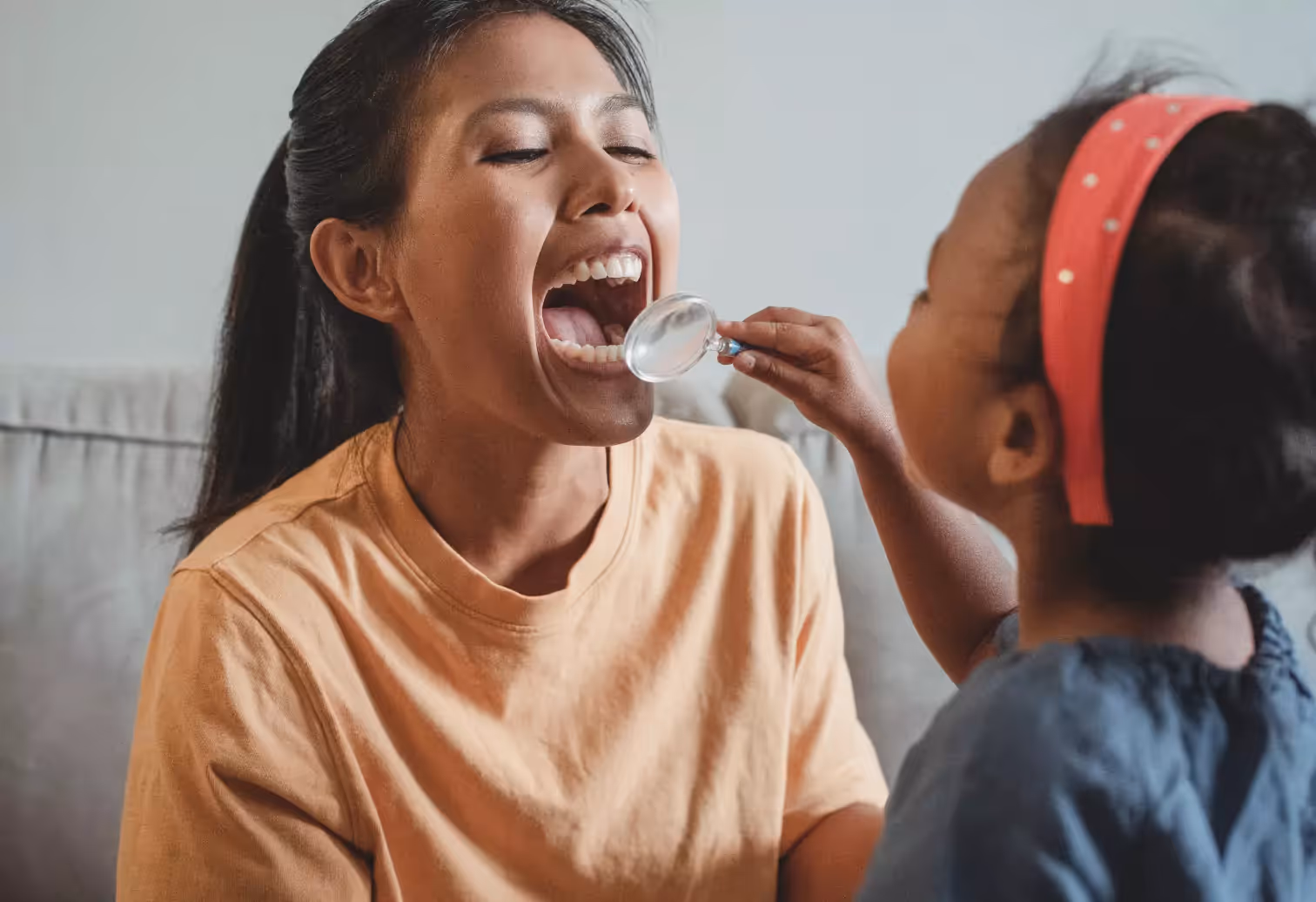 a girl looking at someone's teeth