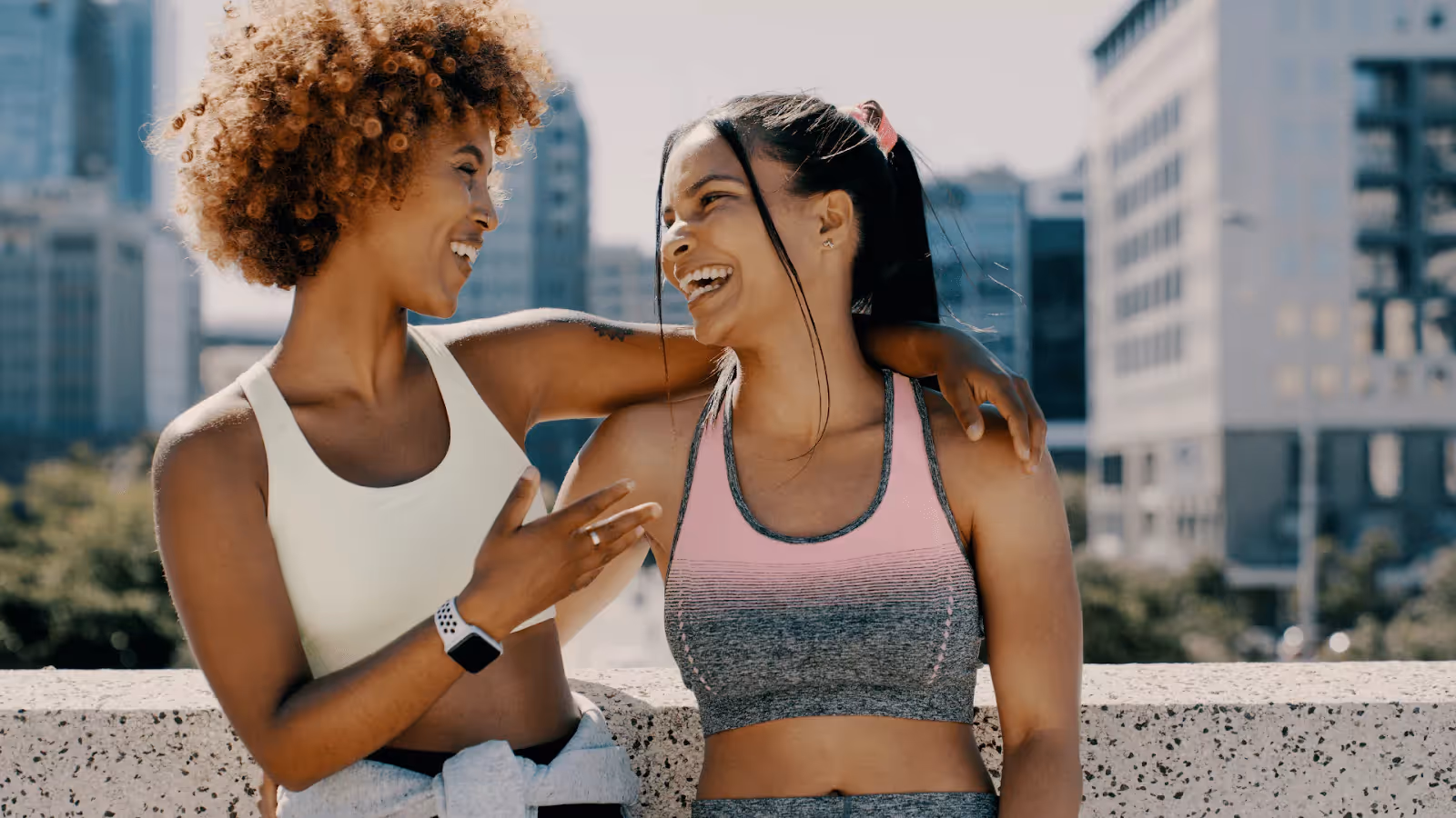 two women in workout gear laughing