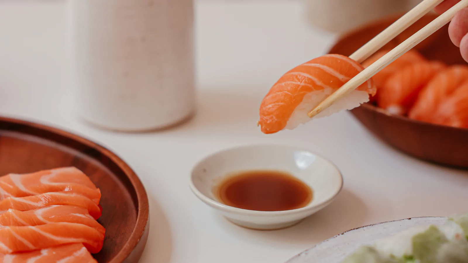 a person holding sushi with chopsticks