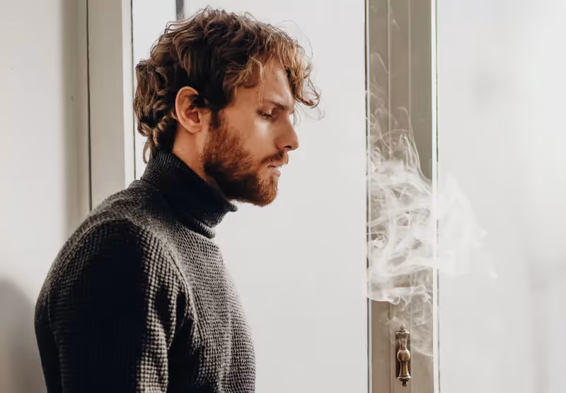 a man standing around a cloud of smoke