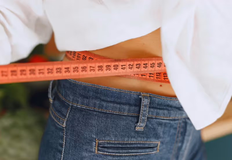 a woman measuring her waist